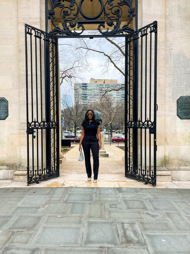 Fashion designer exploring the Rodin Museum in Philadelphia, standing in the elegant sculpture garden with stunning European-inspired architecture in the background.