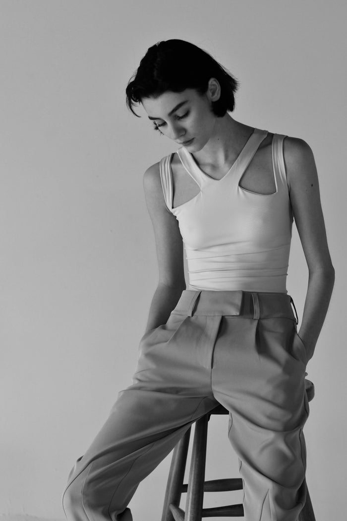 Front view of the Brandy Bodysuit in gray, featuring sleeveless design and stylish cutouts