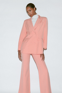 Front view of women's high-waisted peach wide leg pants with front pintucks shown with matching blazer