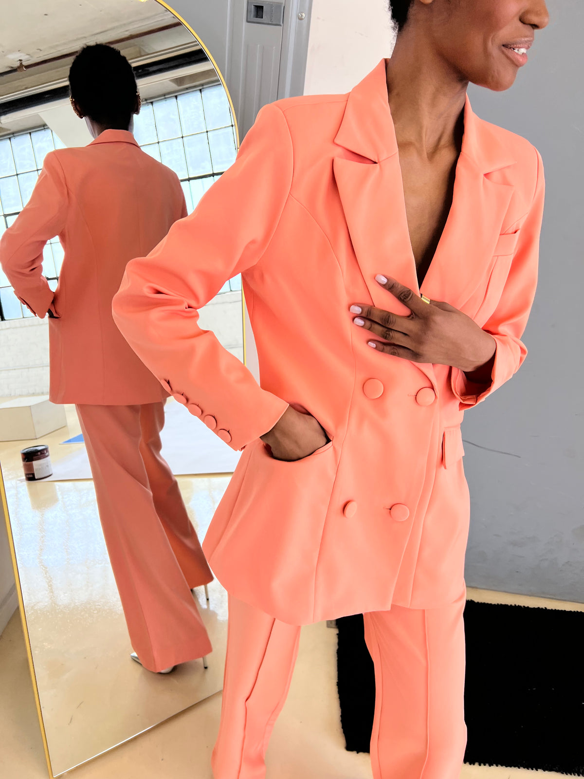 Close-up of TROUSER9 peach double-breasted blazer highlighting matching pants for a complete look