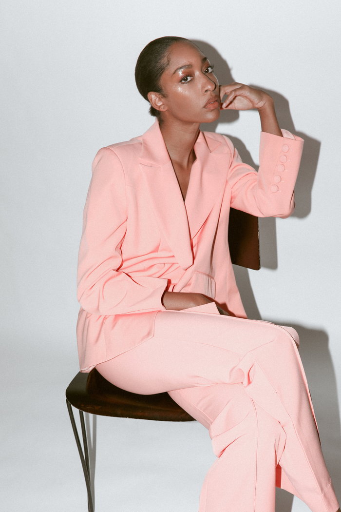 Model wearing peach double-breasted blazer with notched lapel, showcasing the front view and elegant fit