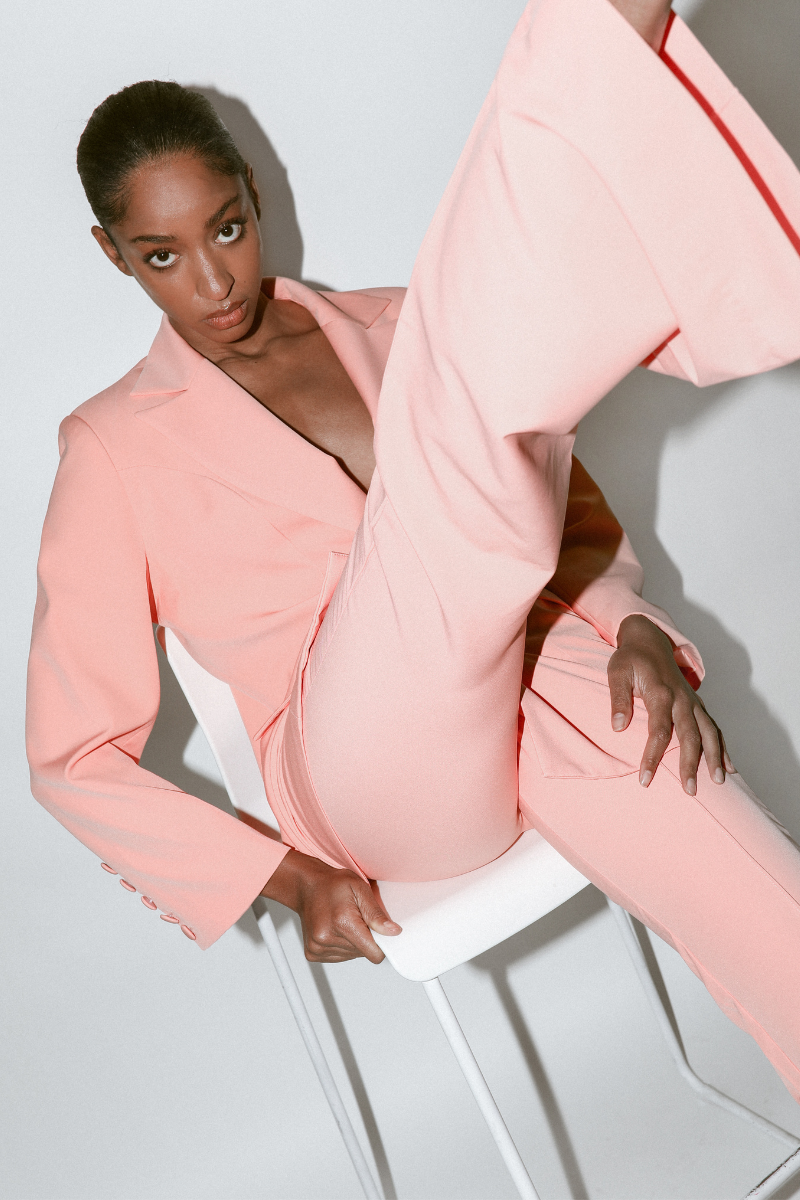 Model wearing peach double-breasted blazer and matching wide leg pants part of a suit