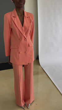 Close-up of peach double-breasted blazer highlighting notch lapel and fabric texture