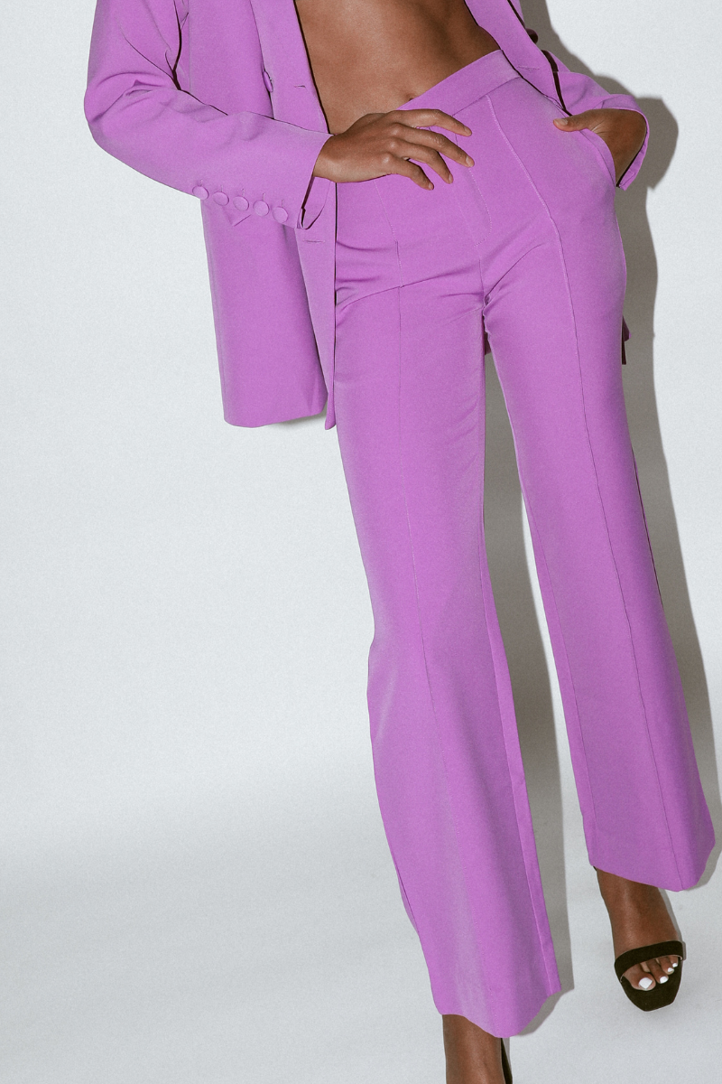 Close-up of purple wide leg pants highlighting front pintucks and high-waisted design